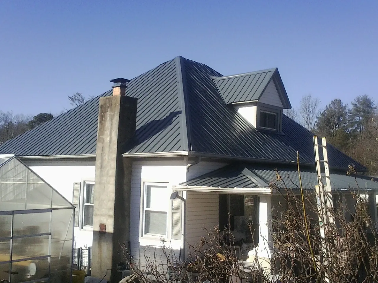 Dark blue standing seam metal roof on a white farmhouse with dormer — Slate & Tile Roof Repair by Roofing Brothers in Brush Prairie