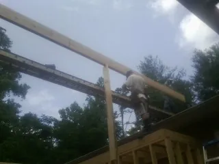 Carpenter setting a ridge beam over a new addition frame — Ice Dam Removal by Roofing Brothers in Brush Prairie