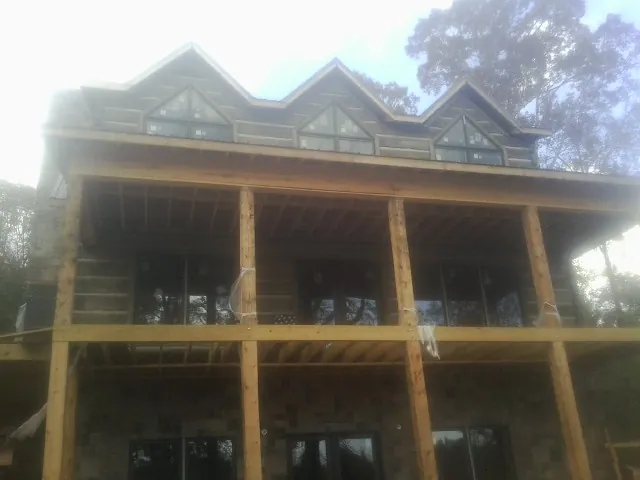 Dormers and porch framing on a large log home under construction — Roof Coating work by our crew in Brush Prairie