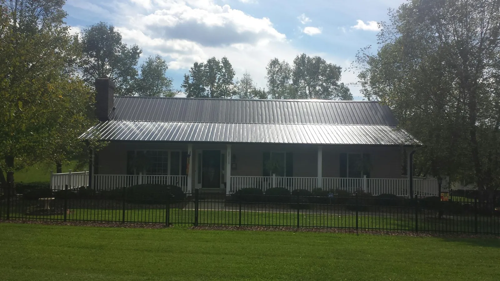 Gray metal roof on a brick ranch with a full width front porch — Gutter Guard Installation work by our crew in Brush Prairie